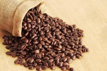 Sack of coffee beans on wooden background