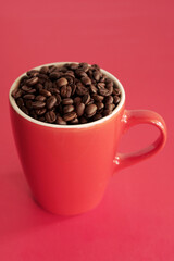 coffee beans in a cup on red background