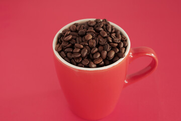 coffee beans in a cup on red background