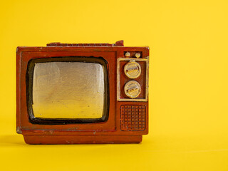 Model of an old TV. Vintage TV on a yellow background.