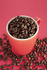 coffee beans in a cup on red background