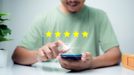 Man using a smartphone to review online store satisfaction rating after receiving an excellent, quality product. The five stars stand out in the center.