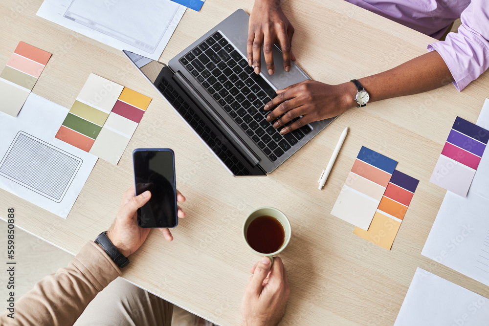 Wall mural top view closeup of two designers using laptop while working on ui project in office, flat lay with 
