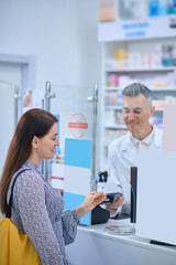 Obraz premium Long-haired woman buying medicines at the drugstore