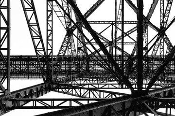 Steel construction of the very high historical railway Bridge “Müngstener Brücke“ between Solingen and Remscheid Germany from below the railroad track. Frog perspective black and white greyscale.