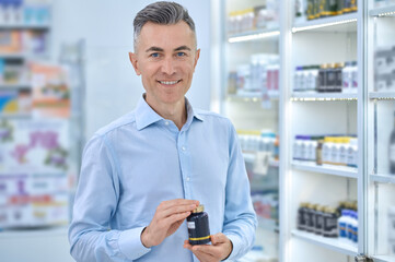 Mid aged man choosing supplements at the drugstore