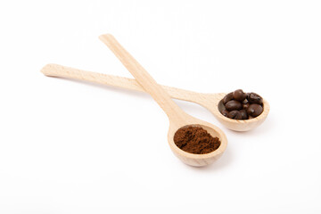 Ground coffee and coffee beans in wooden spoons isolated on white background.