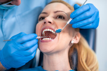 Male dentist checking patient teeth