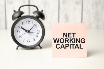 The word Net Working Capital written on pink sticker and alarm clock