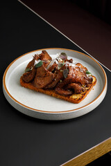 Toast with grilled beef served with herbs on top