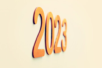 the inscription 2023 going into perspective, made of wooden numbers on the wall
