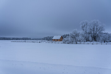 A house in the fields on a snowy winter day