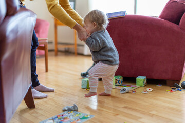 Toddler learning to walk with her mother
