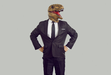 Portrait of serious confident businessman with dinosaur head isolated on gray background. Boss in...