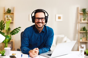 Young smiling man working from home as customer support