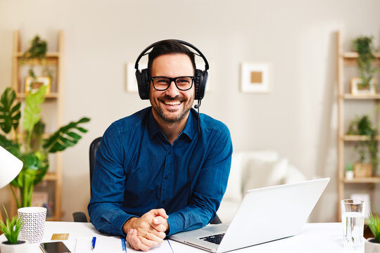 Young smiling man working from home as customer support