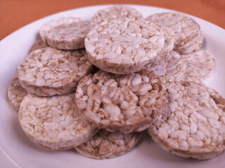 close up of plate with round rice cake Wholegrain at on 
orange background
