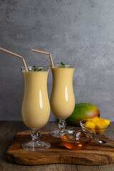 Indian cocktail Lassi on a wooden board in two tall glasses, copy space, close-up