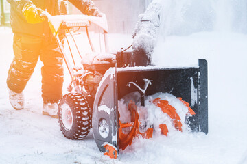a man removes snow with a snow plow after a heavy snowfall near his house