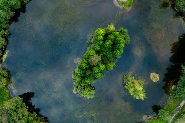 summer view from the drone on lonely island standing on the calm water of the lake