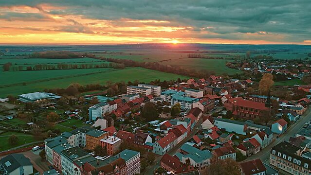 Aerial view of Oschersleben at sunset. Drone flight over the city during twilight with green field in background .  Oschersleben is a town in the Börde district, in Saxony-Anhalt, Germany