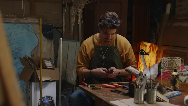 craftman using mobile phone in his workshop 