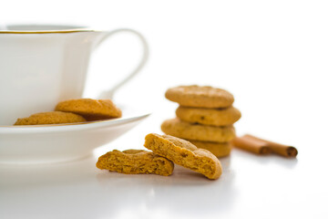 Stacked cookies with a cup and saucer on a white background.