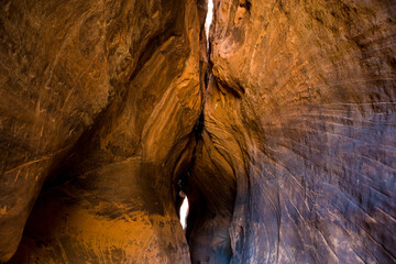 The sides of a narrow slot Canyon touch in Southern Utah with a sliver of light.