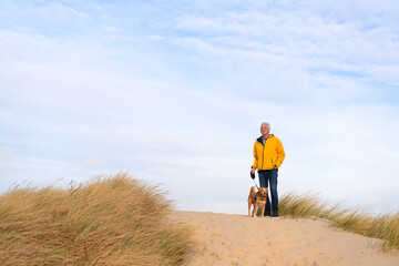 Man with dog on top of the dunes