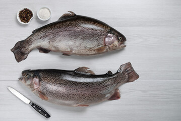 Raw fish with pepper on a white wooden background. Fish trout. Top view. Free space for your text