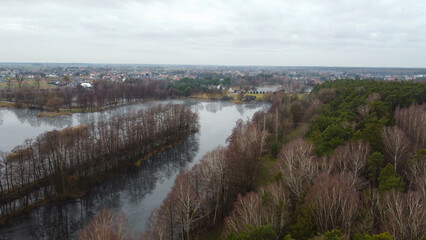 Top view of the river. Dry trees on the banks. In the background of the house. Poland, Opole