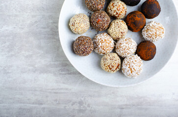 Assorted vegan sweets, Delicious Candy Balls with seeds, dried fruit and cocoa powder, Healthy Candies on a Plate