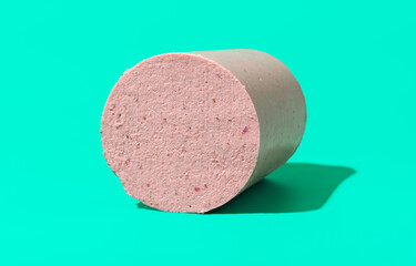 Homemade baloney isolated on a green background. © YesPhotographers