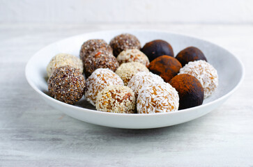 Assorted vegan sweets, Delicious Candy Balls with seeds, dried fruit and cocoa powder, Healthy Candies on a Plate