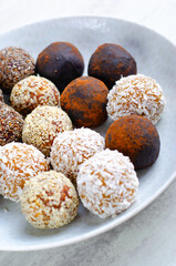 Assorted vegan sweets, Delicious Candy Balls with seeds, dried fruit and cocoa powder, Healthy Candies on a Plate