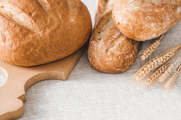 Fresh delicious bread close-up. Freshly baked sourdough bread with a golden crust on a wooden board. The context of a bakery with delicious bread. Confectionery products.
