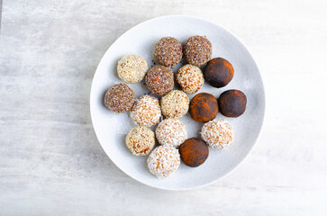 Assorted vegan sweets, Delicious Candy Balls with seeds, dried fruit and cocoa powder, Healthy Candies on a Plate