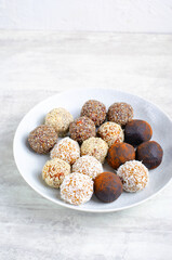 Assorted vegan sweets, Delicious Candy Balls with seeds, dried fruit and cocoa powder, Healthy Candies on a Plate