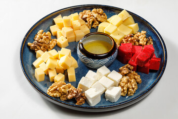 Assortment of cheese and nuts, snacks on plate. Cheese board