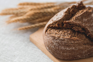 Fresh delicious bread close-up. Freshly baked sourdough bread with a golden crust on a wooden board. The context of a bakery with delicious bread. Confectionery products.