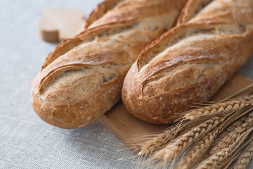 Fresh delicious bread close-up. Freshly baked sourdough bread with a golden crust on a wooden board. The context of a bakery with delicious bread. Confectionery products.