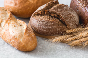 Fresh delicious bread close-up. Freshly baked sourdough bread with a golden crust on a wooden board. The context of a bakery with delicious bread. Confectionery products.