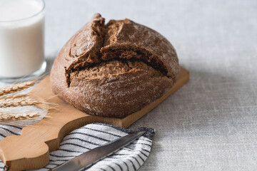 Fresh delicious bread close-up. Freshly baked sourdough bread with a golden crust on a wooden board. The context of a bakery with delicious bread. Confectionery products.