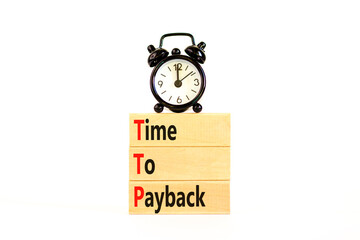 TTP time to payback symbol. Concept words TTP time to payback on wooden blocks on a beautiful white table white background. Black alarm clock. Business TTP time to payback concept. Copy space.