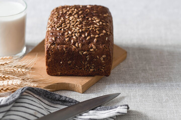 Fresh delicious whole grain rye bread with seeds close-up. Freshly baked bread on a wooden board. The context of a bakery with delicious bread. Confectionery products.