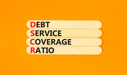 DSCR debt service coverage ratio symbol. Concept words DSCR debt service coverage ratio on wooden stick on beautiful orange background. Business DSCR debt service coverage ratio concept. Copy space.