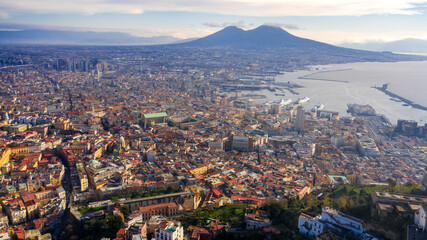 Aerial view of the city of Naples, Italy, and the harbour on a sunny day. The volcano Vesuvius in the background.