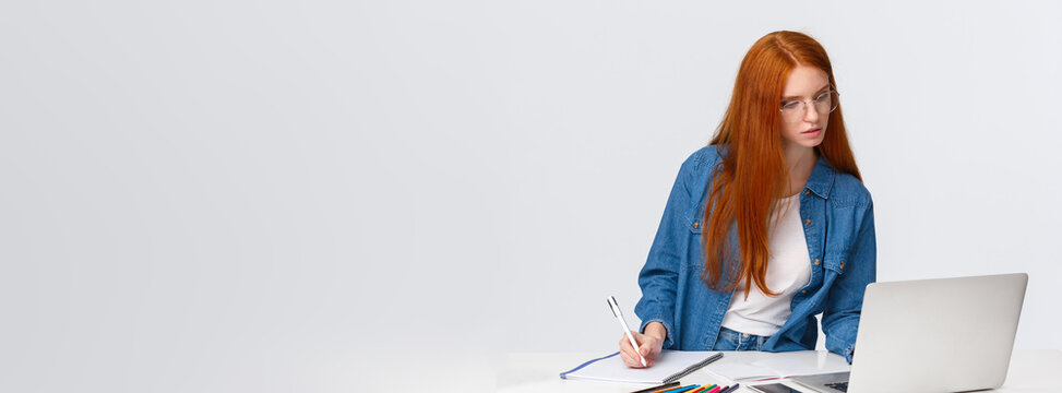 Inspiration, Work And Art Concept. Focused Busy Cute Redhead Female In Glasses, Writing Down Notes From Laptop, Use Useful Website, Online Course To Learn Drawing, White Background