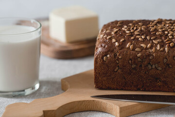 Fresh delicious whole grain rye bread with seeds close-up. Freshly baked bread on a wooden board. The context of a bakery with delicious bread. Confectionery products.