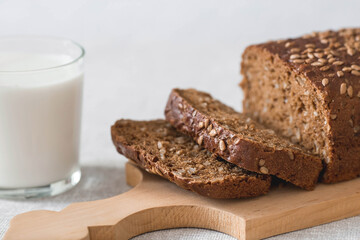 Fresh delicious whole grain rye bread with seeds close-up. Freshly baked bread on a wooden board. The context of a bakery with delicious bread. Confectionery products.